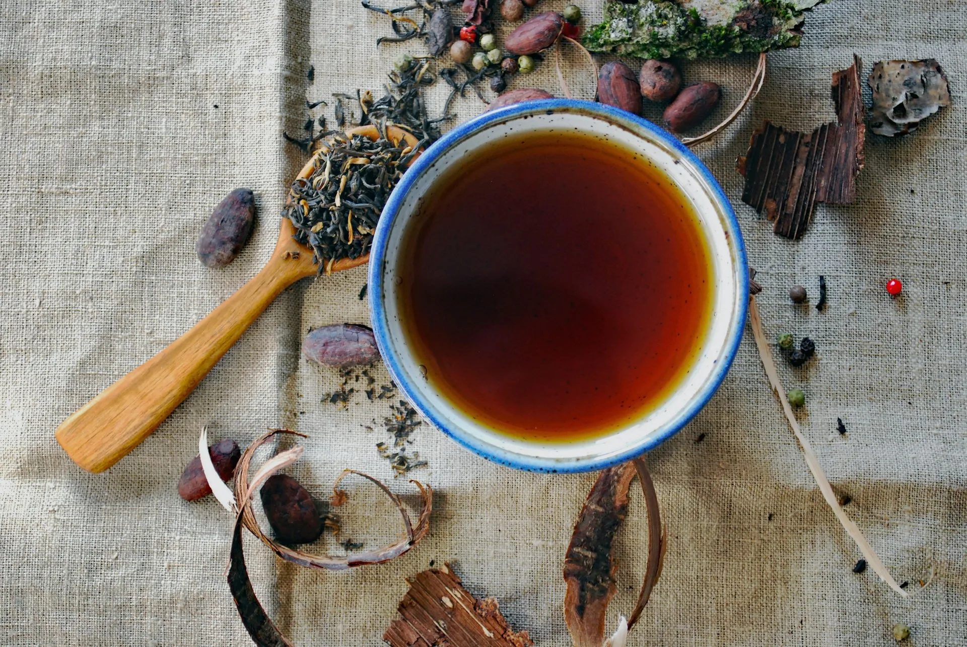 A cup of black tea with spoon and spices